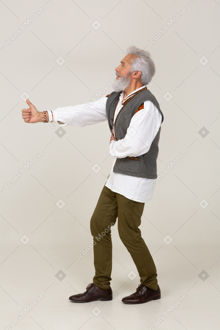 Vista lateral de um homem em roupas casuais dando polegares para cima