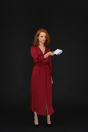 Bella giovane donna vestita di rosso e con in mano un blocco note