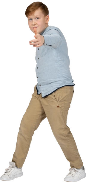 Front view of a cute boy pointing at camera