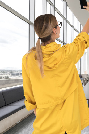 Femme en imperméable prenant des selfies