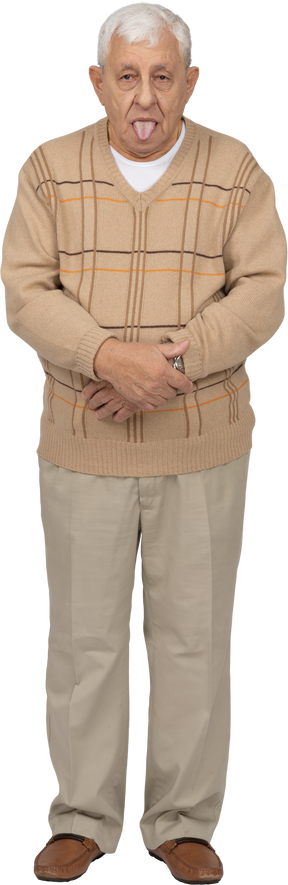 Вид спереди на старика в повседневной одежде, показывающего язык