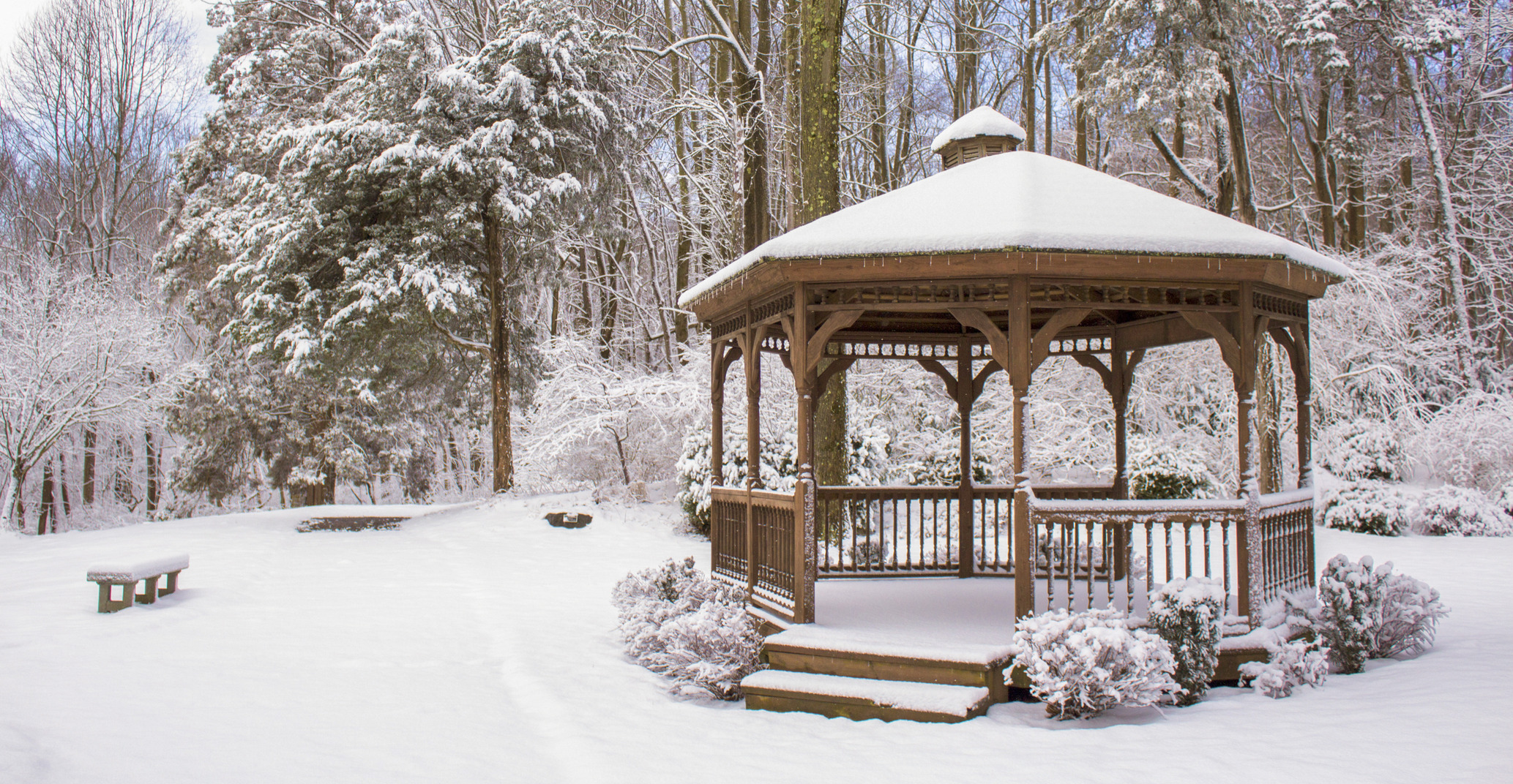 Wooden gazeebo covered in snow