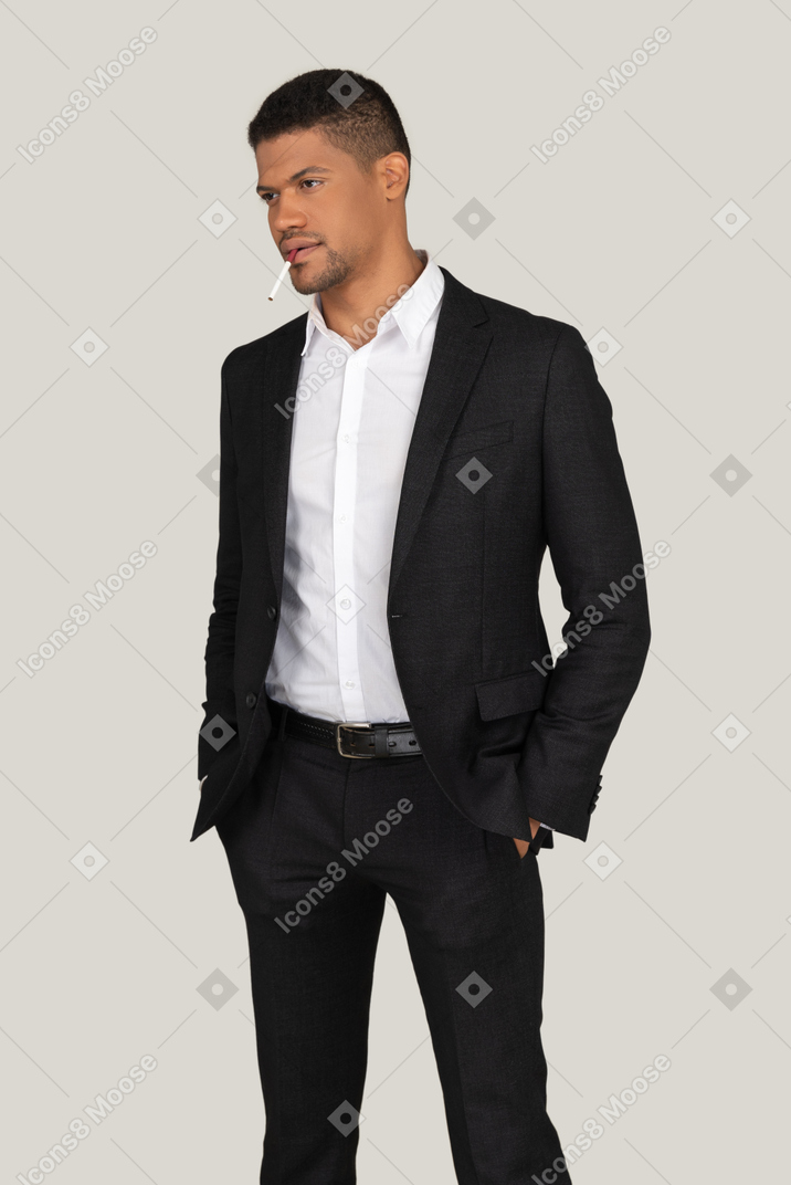 Young guy in a black suit smoking a cigarette