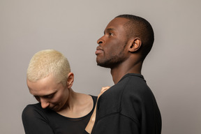 Young woman standing close to man looking down