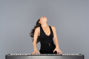 Woman bending her head back while playing a piano