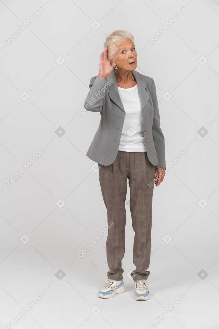 Front view of an old lady in suit looking at camera and listening attentively