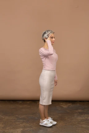 Side view of a woman in casual clothes touching head with finger