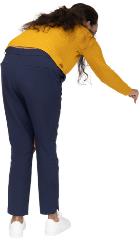 Rear view of a girl in casual clothes bending down with extended arm