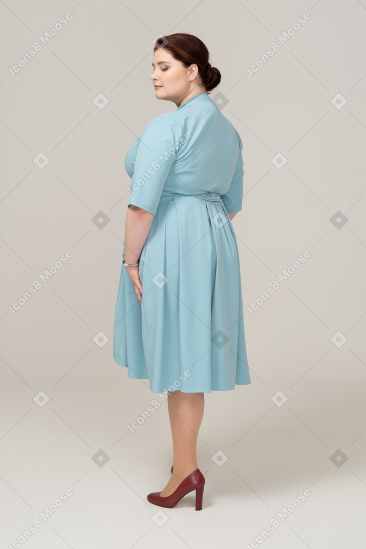一个穿蓝色裙子的女人的后视图