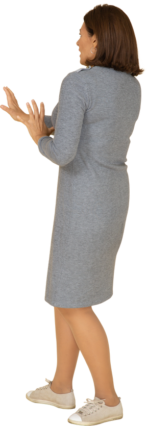 Vista lateral de uma mulher assustada em um vestido cinza