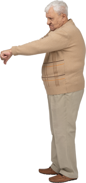 Vista lateral de um velho em roupas casuais, mostrando o polegar para baixo