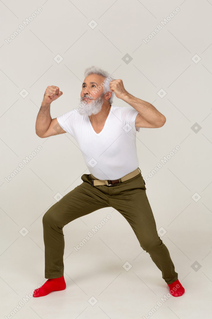 Homem em roupas casuais flexionando os músculos do braço