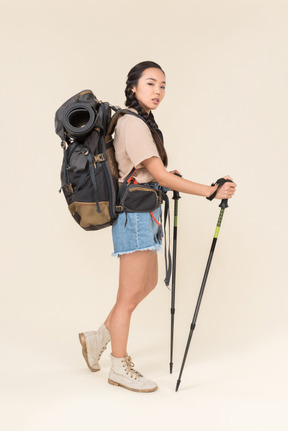 Donna escursionista in piedi con bastoncini da trekking