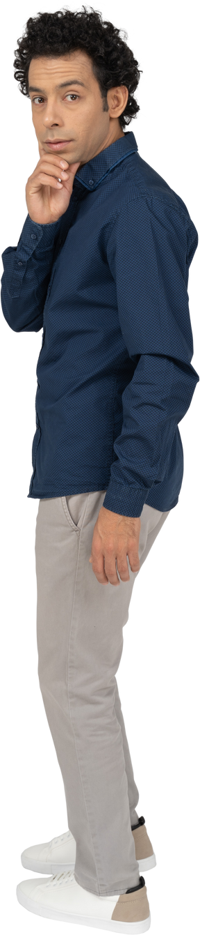 Vue latérale d'un homme en vêtements décontractés touchant son menton