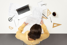 A female architect working on architectural drawings