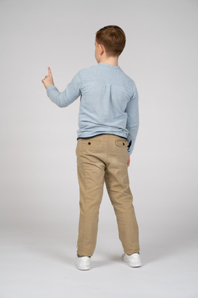 Back view of a boy pointing up with finger