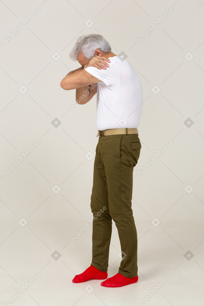 Vista lateral de un hombre con ropa informal escondiendo la cara en los brazos