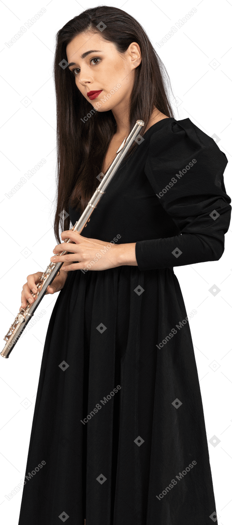 Vista frontal de uma jovem de vestido preto segurando uma flauta