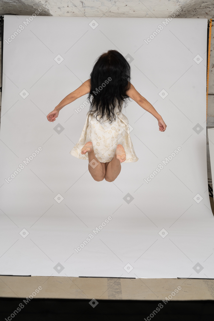Woman in beautiful dress jumping