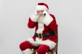 Pensive santa claus talking on the phone