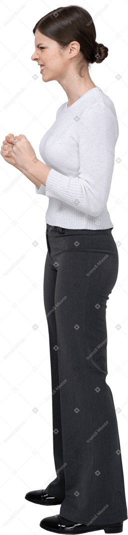 Side view of a furious woman in office clothing clenching fists