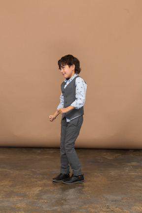 一个穿着西装跳舞的男孩的侧视图