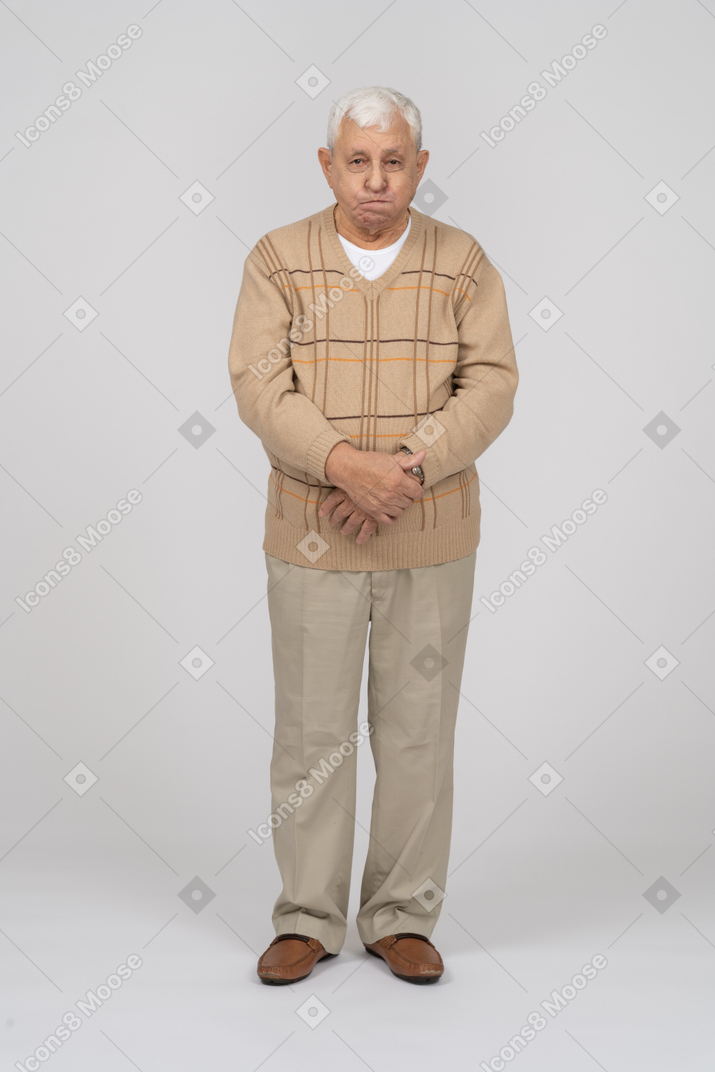 Front view of an old man in casual clothes making faces