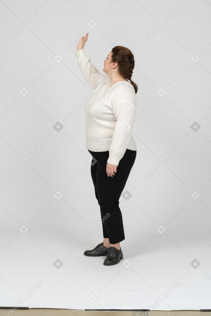Side view of a plump woman in casual clothes greeting someone