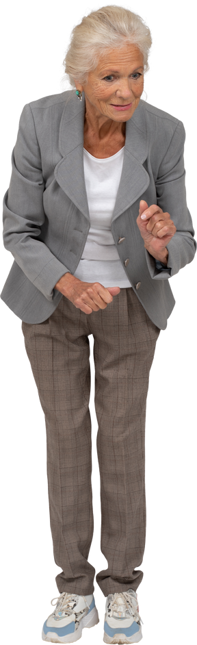 Front view of an impressed old woman in suit bending down