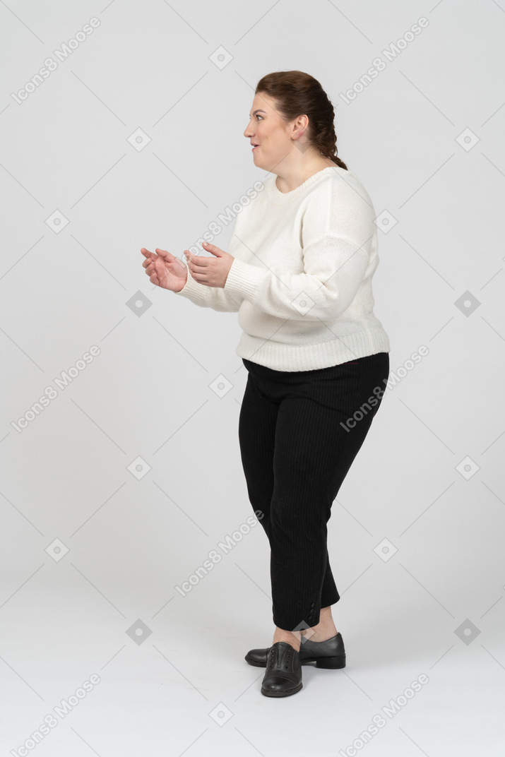 Удивленная пухлая женщина в белом свитере