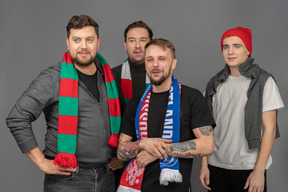 Close-up of four male football fans looking aside