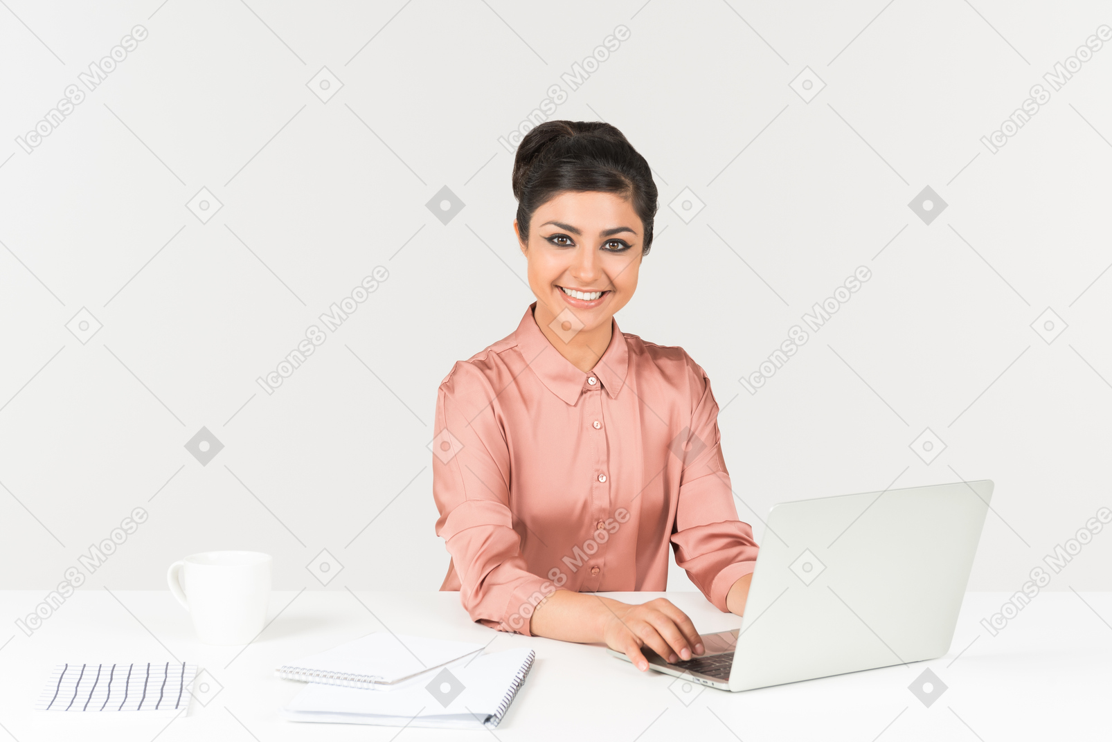 Smiling young indian office worker working on the laptop