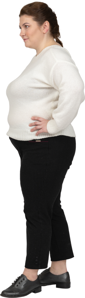 더하기 크기 여자 엉덩이에 손으로 서 흰색 스웨터