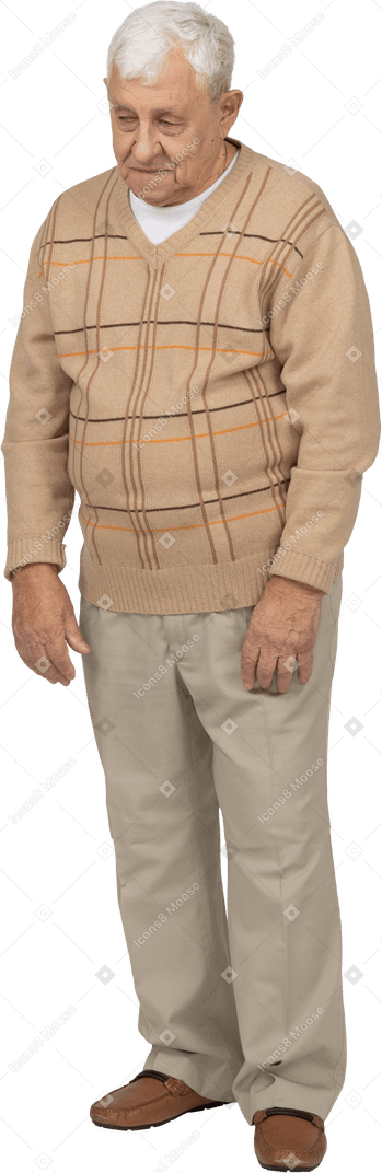 Front view of an old man in casual clothes looking at something with interest