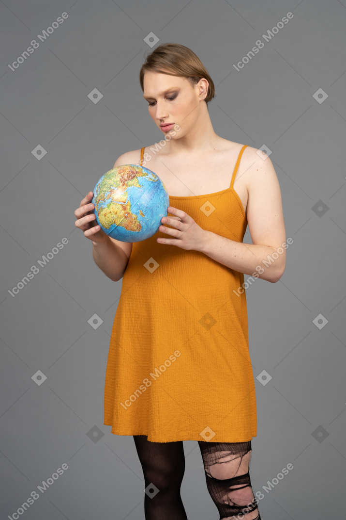 Portrait of a non-binary person holding miniature planet earth