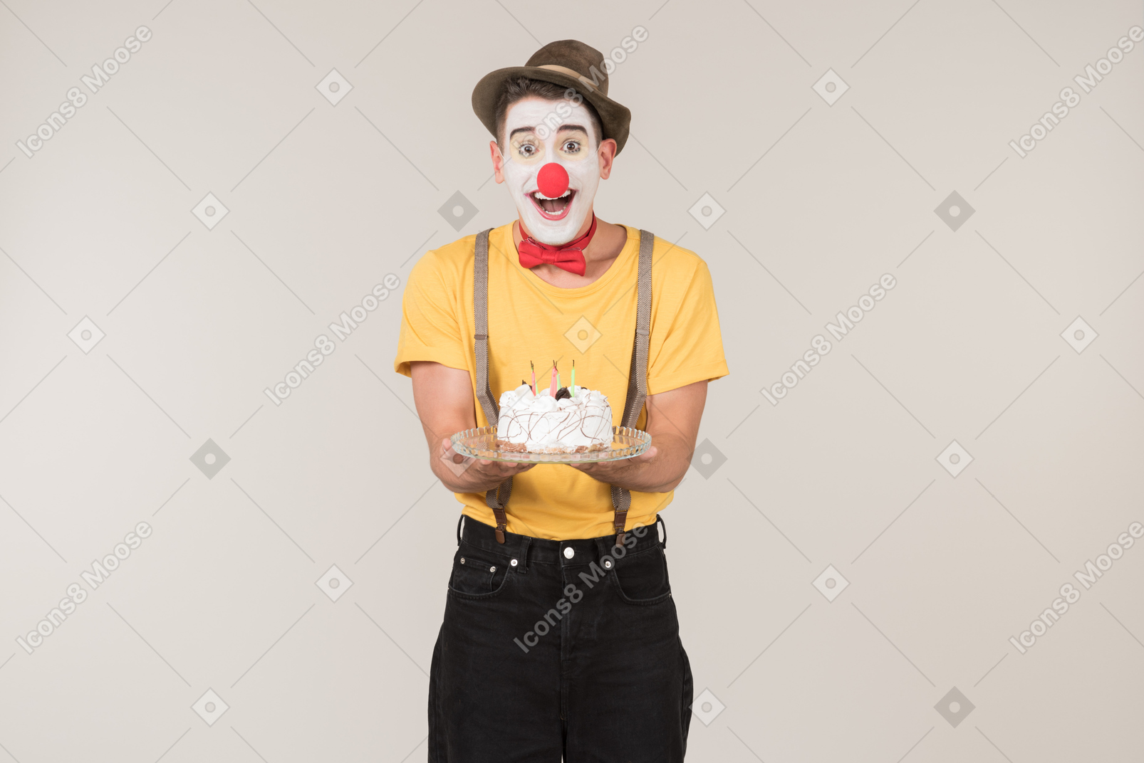Excited male clown holding a cake