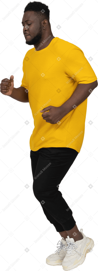 一个穿着黄色 t 恤的黑皮肤年轻男子跑步的四分之三视图