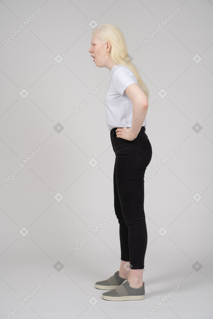 Side view of a young woman with her hands on hips