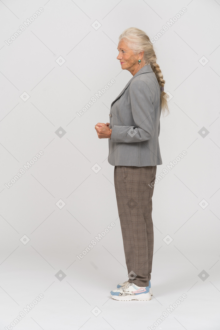 Side view of an angry old lady in suit showing fist