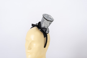 Small silver top hat with a bow on a mannequin head