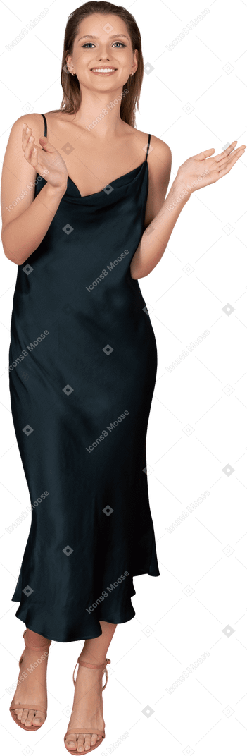 Вид спереди хлопающей молодой женщины в ночном платье, стоящей на красной ковровой дорожке