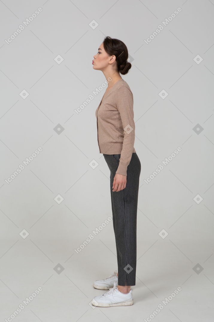 Side view of a pouting young lady in pullover and pants