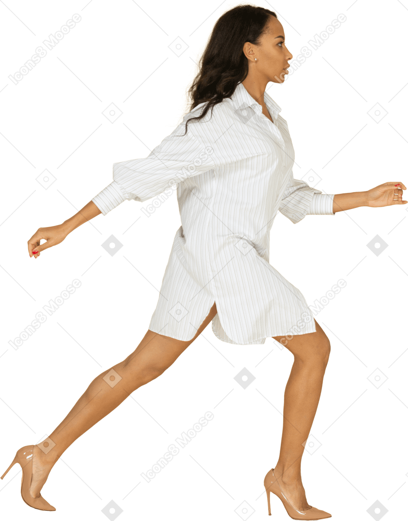深色皮肤的年轻女性穿着白色连衣裙迈出一大步的侧视图