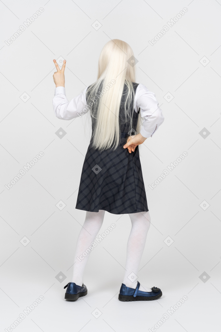 Back view of a schoolgirl making peace sign