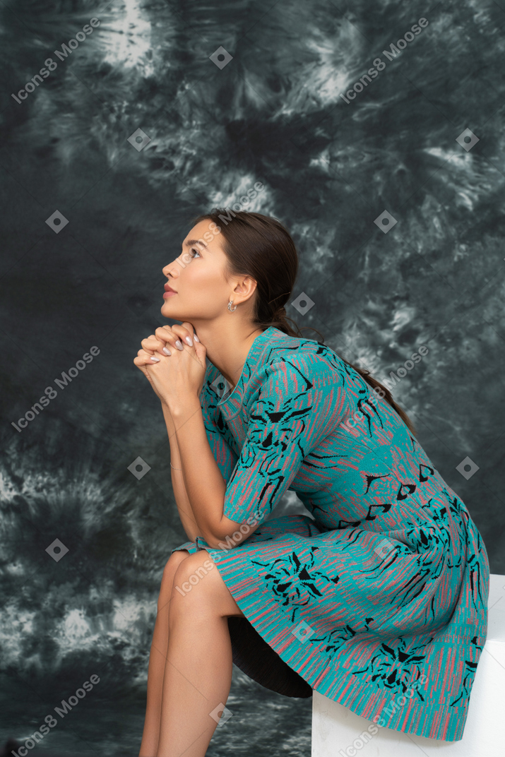 Side portrait of a lady in blue looking up