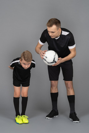 Full-length of a young man coaching little boy