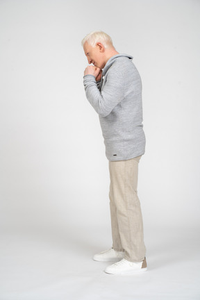 Side view of a man standing with clenched fists near his face