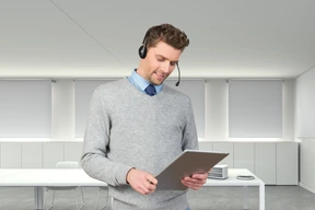 A man wearing a headset and using a tablet