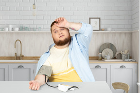 A man sitting at a table and measuring blood pressure