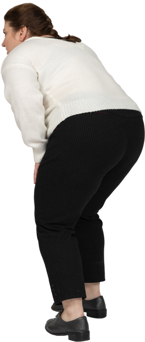 Rear view of a plump woman bending down